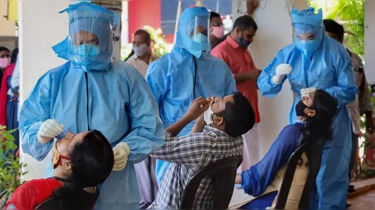 Health workers collect swab samples from corporation employees for Covid-19 tests.