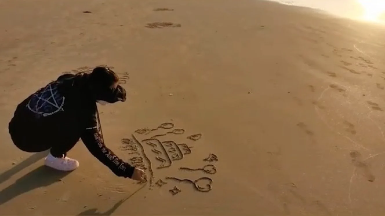 Woman quits sales job to draw messages on sandy beaches for others