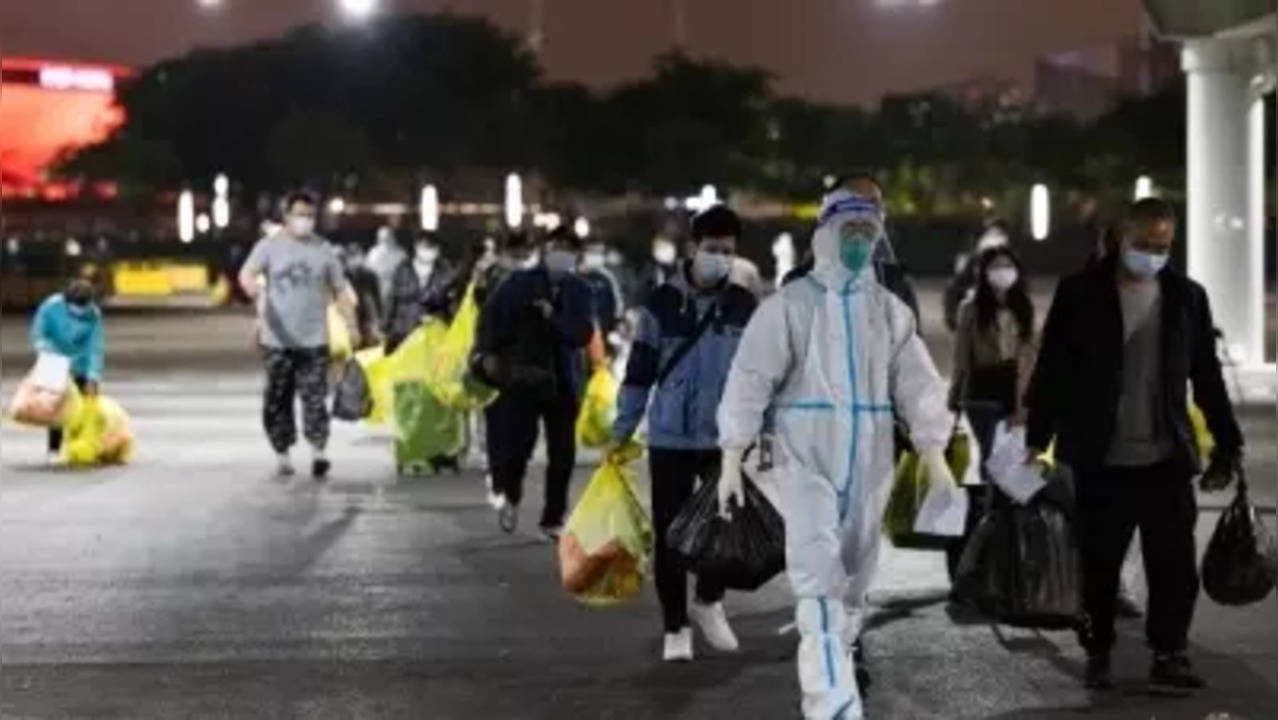 A medical worker leads recovered COVID-19 patients leaving a makeshift hospital in Shanghai, east China, April 23, 2022. (Xinhua/Jin Liwang/IANS)