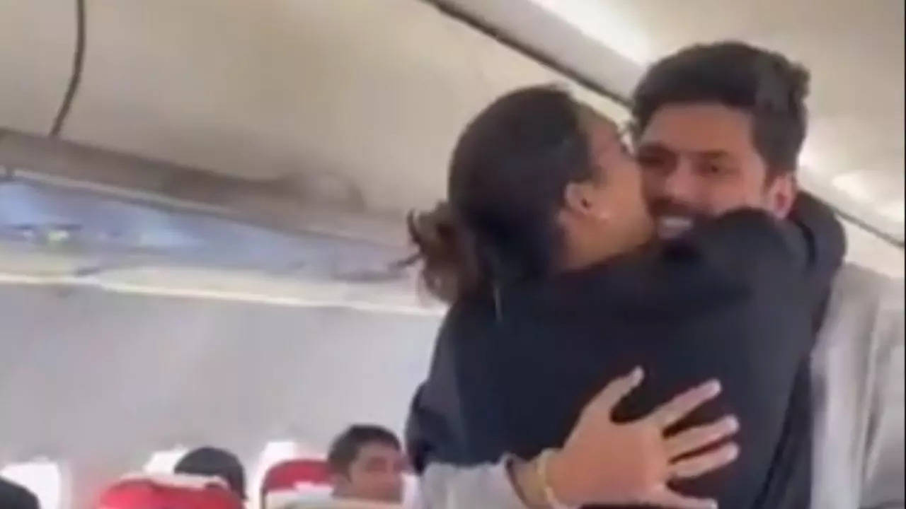 A couple embraces each other mid-air aboard an Air India flight during a surprise marriage proposal | Screengrab: Twitter