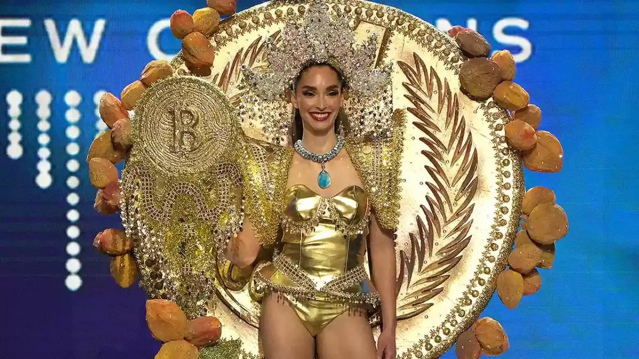 Miss El Salvador Alejandra Guajardo wields a golden staff with a Bitcoin logo on top at the 71st Miss Universe pageant | Picture courtesy of @EricaFails/Twitter