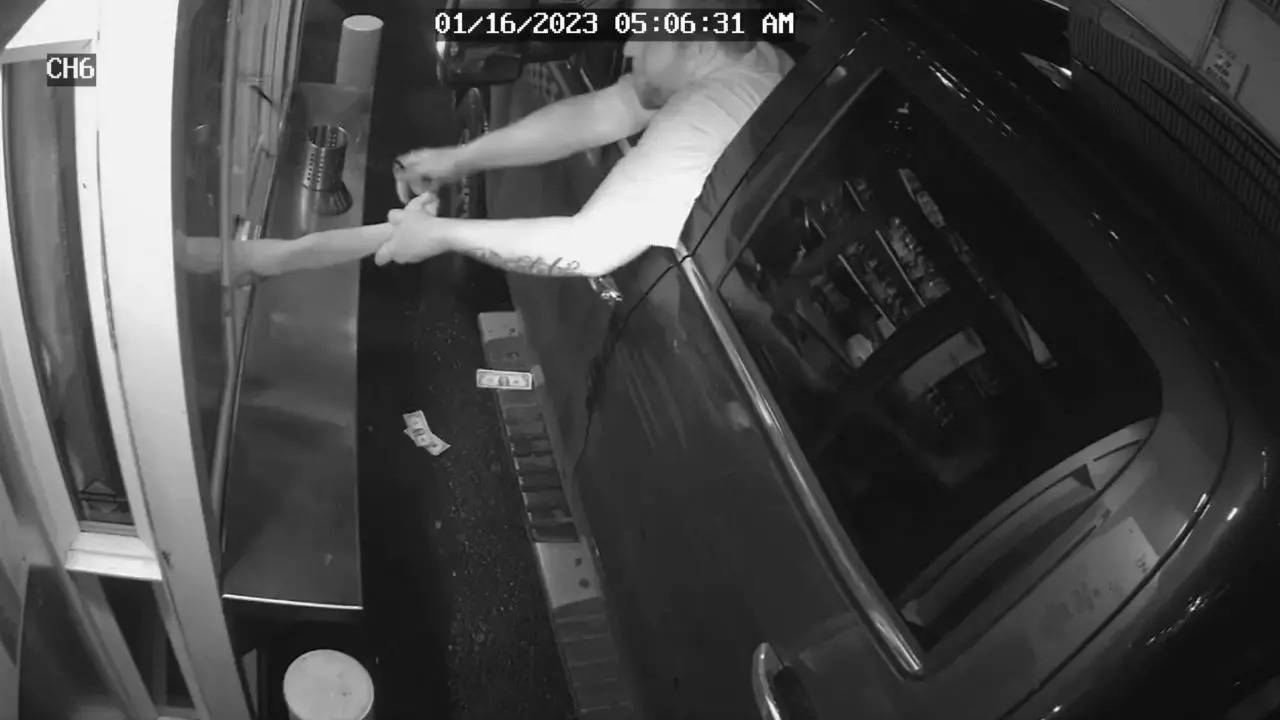 Surveillance camera footage captures a man trying to kidnap a barista by pulling her through the drive-thru's window | Screengrab: @AuburnWAPolice/Twitter