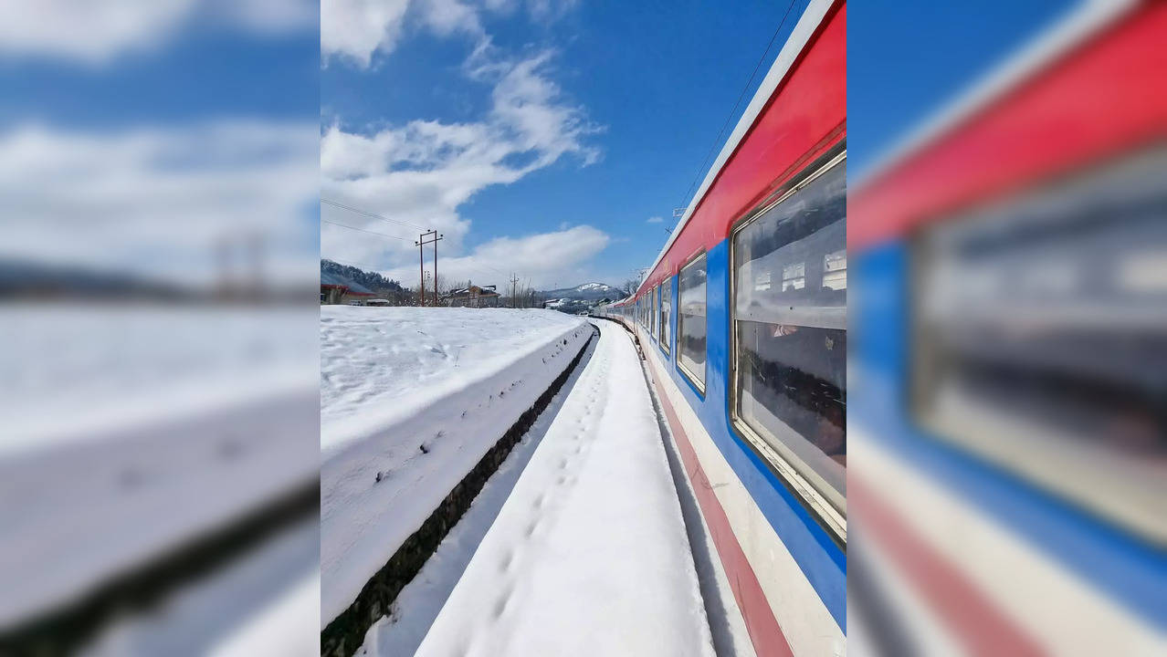 Train passes through snow-covered station