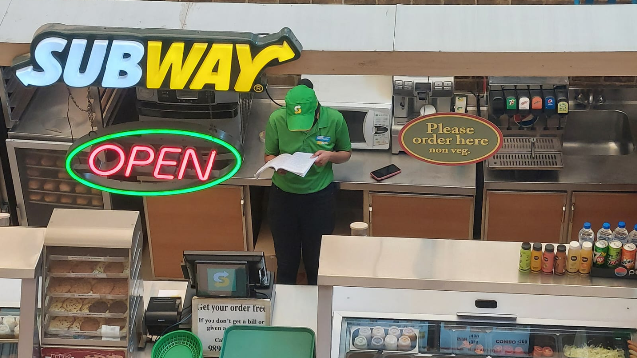 Subway employee studies at work