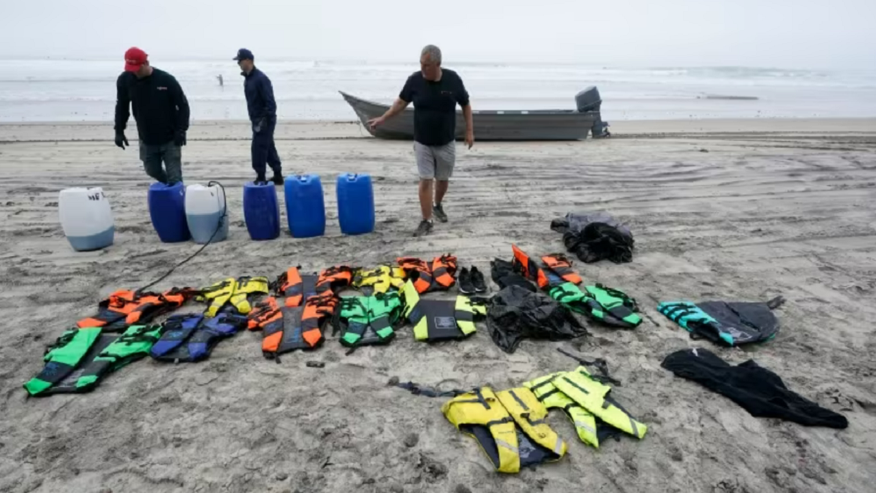 Boat salvager Robert Butler, right, and KC Ivers pick up items in front of one of two boats on Blacks Beach in San Diego, Calif., on Sunday.