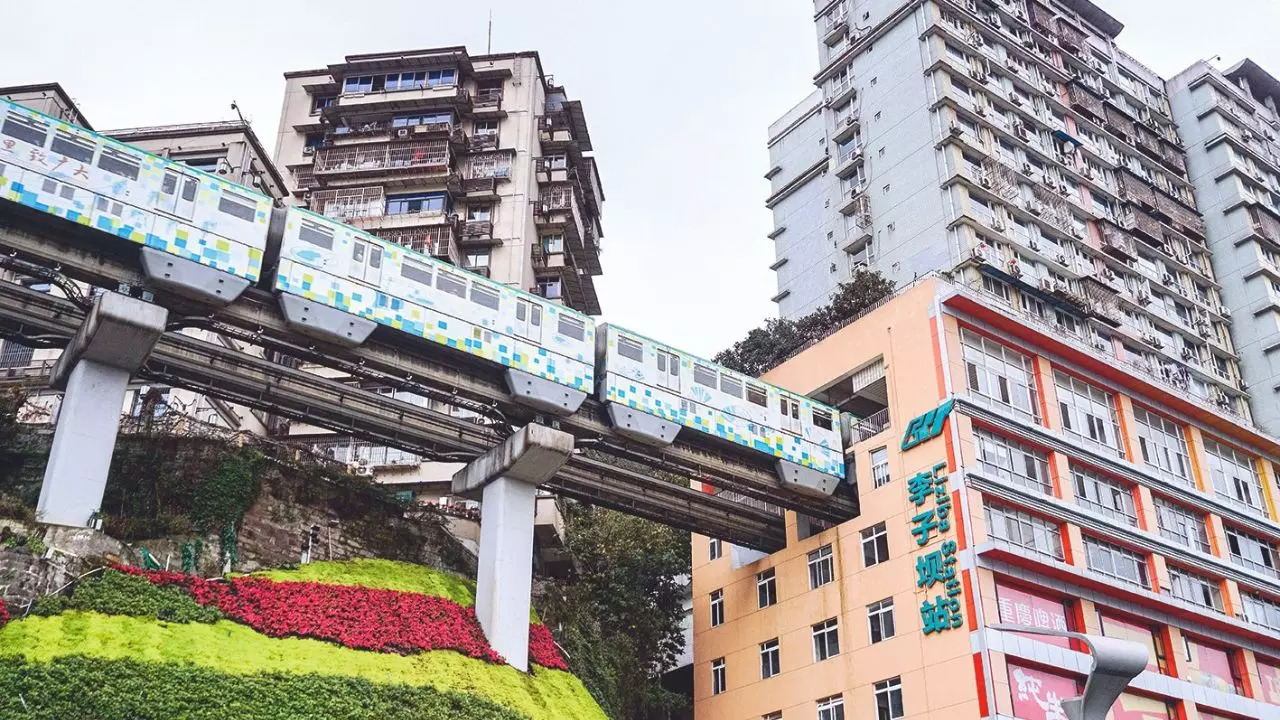 Behold the Chongqing Rail Transit at the Liziba monorail station, located between the sixth and eighth floors of a 19-story residential building in the heart of China's bustling city of Chongqing. The train passing through the building has become a symbol of the country's engineering prowess and ambition. | Courtesy: Twitter