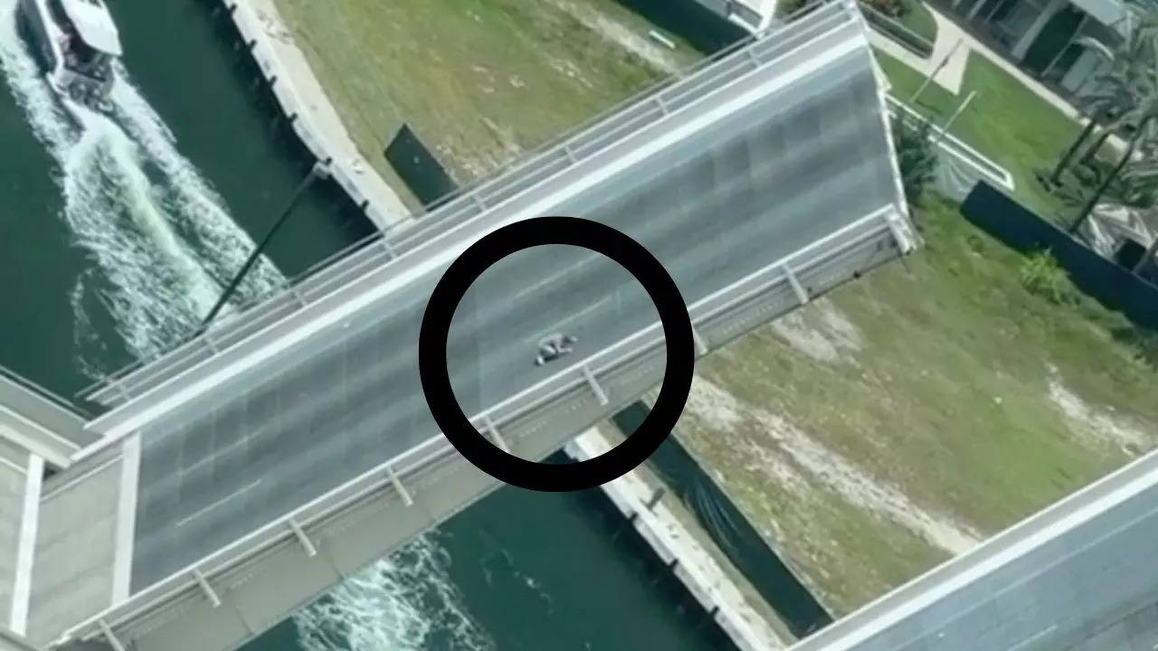 An unidentified Florida man holds on for his dear life as Miami's Brickell Bridge is raised and lowered to allow boats to pass underneath | Screenshot: the.mikeball | TikTok/Twitter