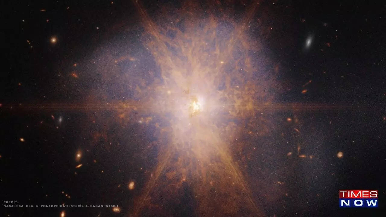 This cosmic display is the merging cores of two colliding galaxies, with brilliant light from surrounding star formations creating diffraction spikes that dominate the image.