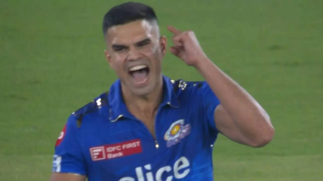 Arjun Tendulkar celebrates Wriddhiman Saha's wicket.